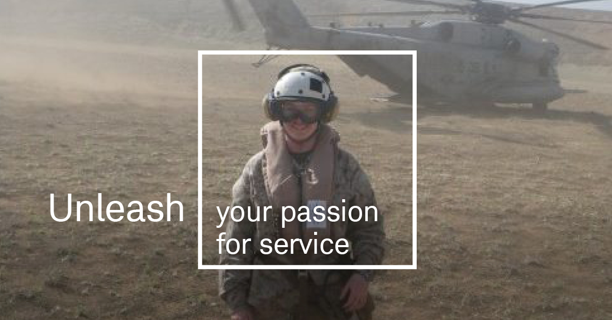 Women in military uniform in front of helicopter.